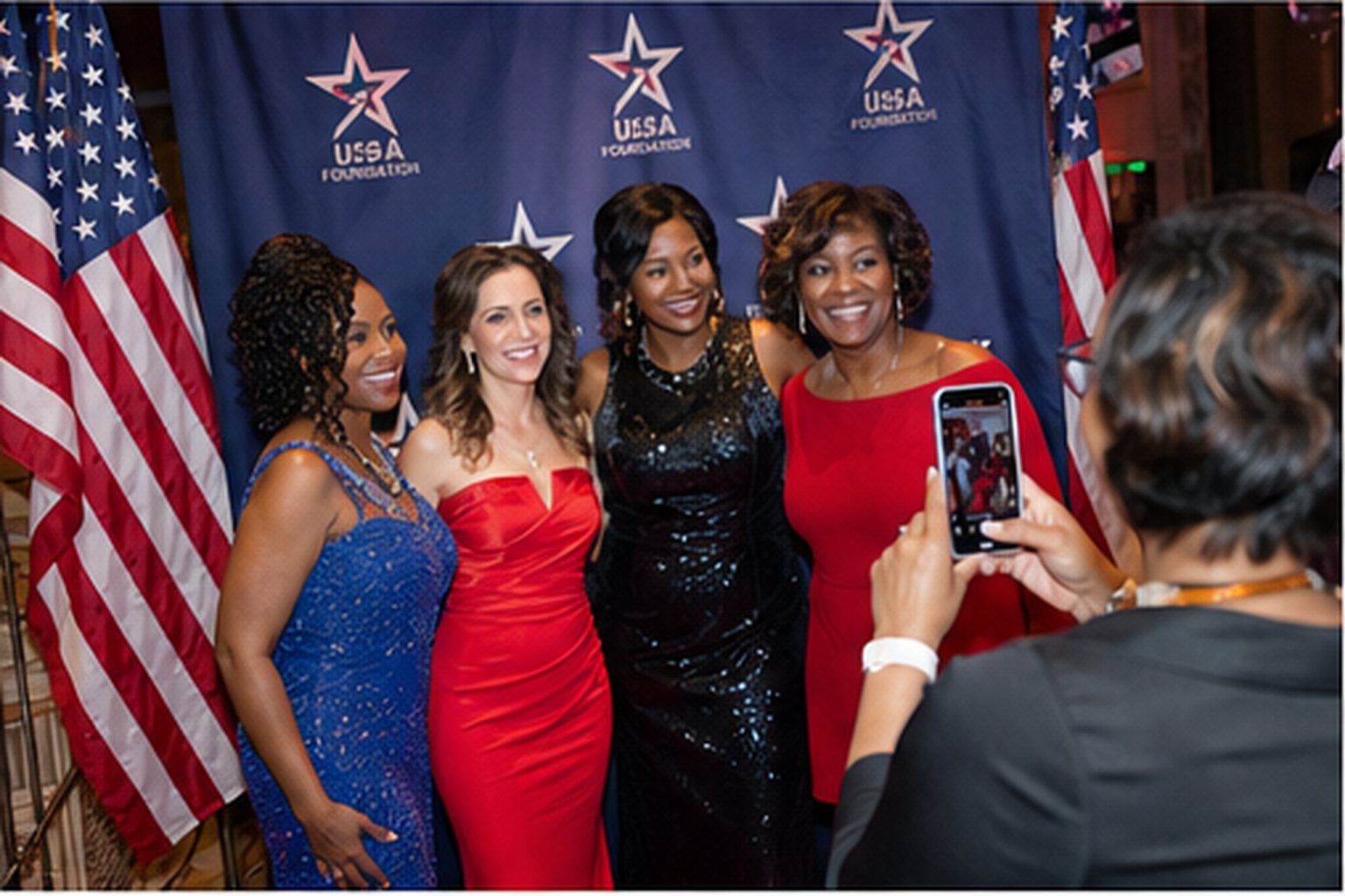 Guests posing together for a photo at the patriotic step-and-repeat backdrop