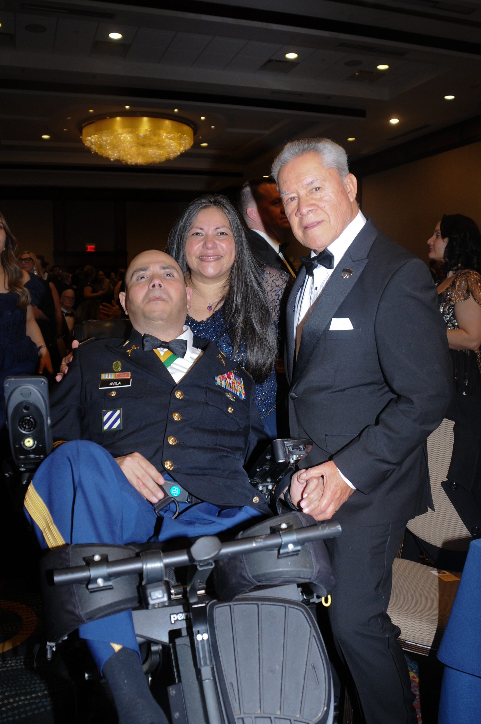 Wounded veteran with family and a fellow officer celebrating at the ball